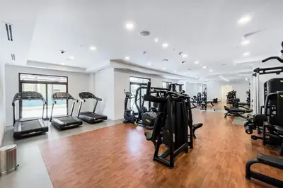 a gym with lots of treadmills and elliptical machines at Asayel Apartments in Dubai