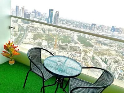 a table and two chairs in a balcony with a view at Top Floor Luxurious Apt in JVC, Near Marina in Dubai