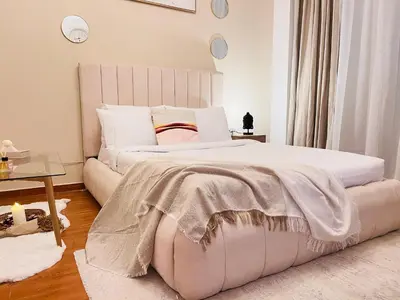 a bedroom with a large white bed and a table at Aesthetically Designed Lavish Apt, Near Marina in Dubai
