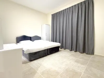 a bedroom with two beds and a curtain at Barsha Star Residence 2-HomeStay in Dubai