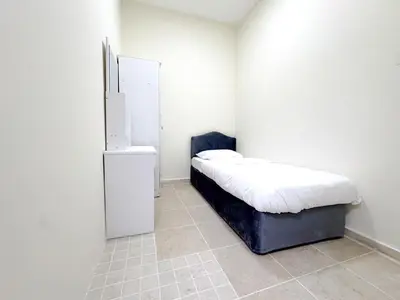 a room with a bed and a refrigerator at Barsha Star Residence 2-HomeStay in Dubai