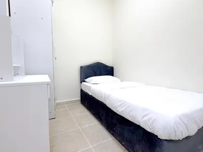 a small bedroom with two beds and a counter at Barsha Star Residence 2-HomeStay in Dubai