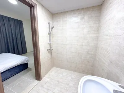 a bathroom with a shower and a sink and a bed at Barsha Star Residence 2-HomeStay in Dubai