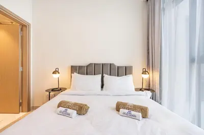 a bed with two towels on top of it at Bright & Modern Home with Burj Khalifa Views in Dubai
