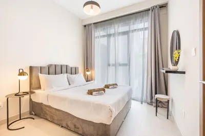 a bedroom with a large bed and a large window at Bright & Modern Home with Burj Khalifa Views in Dubai