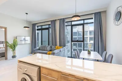 a kitchen and living room with a couch and a table at Bright & Modern Home with Burj Khalifa Views in Dubai
