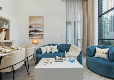 a living room with blue couches and a table at Luxurious 2-bedroom Apartment in Downtown with Burj Khalifa View in Dubai