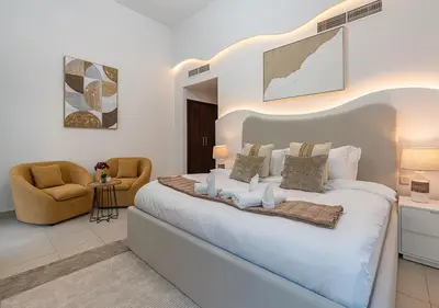 a bedroom with a large white bed and a chair at Luxurious 2-bedroom Apartment in Downtown with Burj Khalifa View in Dubai