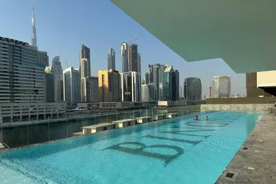 a swimming pool with a city skyline in the background at Opulent Lifestyle with Burj Khalifa and Canal View in Dubai