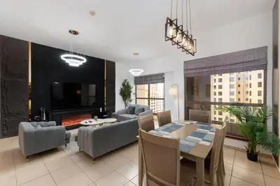 a living room with a table and a fireplace at Sadaf 5, Jumeirah Beach Residence, JBR - Mint Stay in Dubai