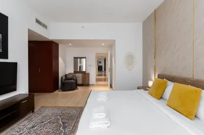 a bedroom with a large white bed with yellow pillows at Sadaf 5, Jumeirah Beach Residence, JBR - Mint Stay in Dubai