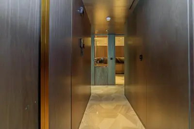 a hallway with wooden walls and a door with a mirror at Luxury 3BDR Apartment, Pool & Beach Access in Dubai