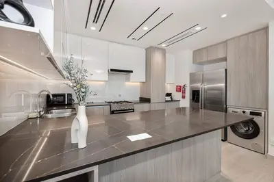 a kitchen with a vase of flowers on a counter at Luxurious 3Bedroom Apartment in Dubai