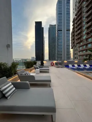 a rooftop patio with couches and chairs on a building at Luxurious 3Bedroom Apartment in Dubai
