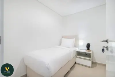 a white bedroom with a bed and a night stand at Vogue Downtown Views II with Direct Access to Dubai Mall Via a Climate Controlled Bridge, Three Bedroom Apartment plus kids room and Balcony with Burj Khalifa View in Dubai