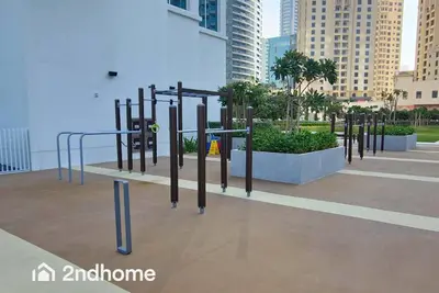 a playground in a city with tall buildings at La Vie, JBR - Your Perfect Holiday Gateway in Dubai