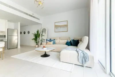 a white living room with a white couch and a table at La Vie, JBR - Your Perfect Holiday Gateway in Dubai