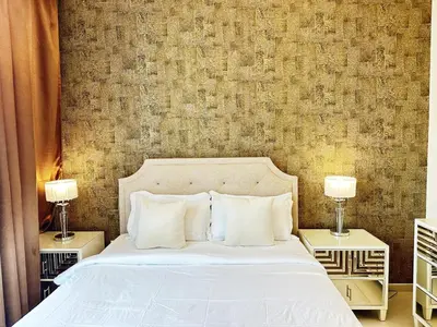 a bedroom with a white bed with two night stands at Modern Elegance in Downtown 1BR with Luxe Decor by Petals Holiday Homes in Dubai