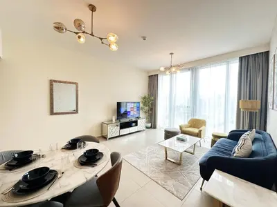 a living room with a table and a couch at Modern Elegance in Downtown 1BR with Luxe Decor by Petals Holiday Homes in Dubai