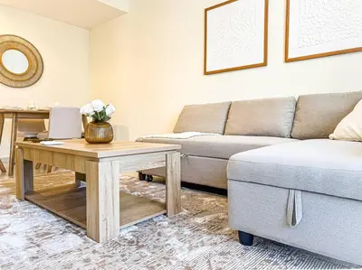 a living room with a couch and a table at DreamShoma -1B Spacious Apartment with a Lake View in Dubai
