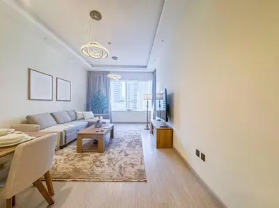 a living room with a couch and a table at DreamShoma -1B Spacious Apartment with a Lake View in Dubai