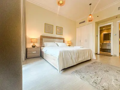a bedroom with a large white bed and a nightstand at DreamShoma -1B Spacious Apartment with a Lake View in Dubai