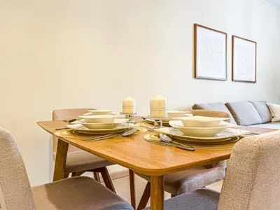 a dining room table with plates and candles on it at DreamShoma -1B Spacious Apartment with a Lake View in Dubai