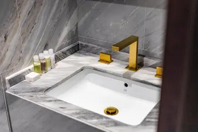 a bathroom with a white sink and a faucet at Superluxury Apartment in FIVE Palm, Pool & Beach Access in Dubai
