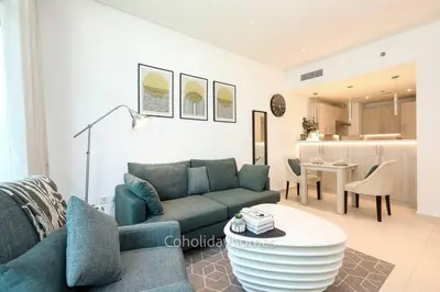 a living room with a couch and a table at 1 BR Rooftop Infinity Pool & Padel court in Dubai