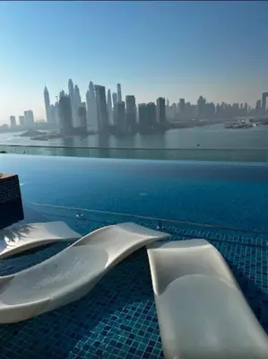 a swimming pool with a view of a city at 1 BR Rooftop Infinity Pool & Padel court in Dubai