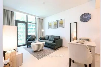 a living room with a couch and a table at 1 BR Rooftop Infinity Pool & Padel court in Dubai