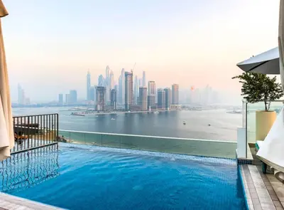a large swimming pool with a view of the city at 1 BR Rooftop Infinity Pool & Padel court in Dubai