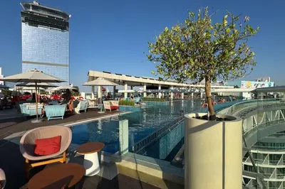 a swimming pool with a tree on top of a building at 1 BR Rooftop Infinity Pool & Padel court in Dubai
