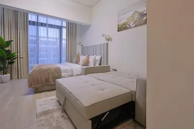 a bedroom with a bed and a large window at Brand New Studio Near Downtown Dubai in Dubai