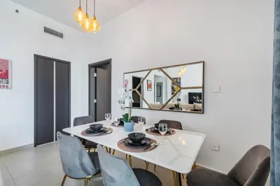 a dining room with a white table and chairs at Classy Downtown Bliss with Dubai Mall Access in Dubai