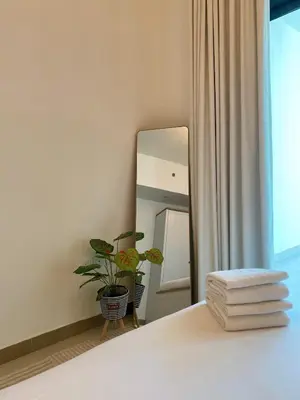 a bedroom with a mirror and a pile of towels at Sleek 1BR in DSO, Dubai in Dubai