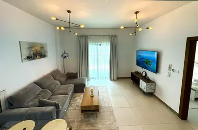 a living room with a couch and a table at Sleek 1BR in DSO, Dubai in Dubai