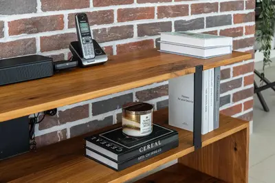 a wooden shelf with books and a phone on it at Arthouse Royale - 2BR with Burj Khalifa Views, Swimming Pool & Gym in Dubai