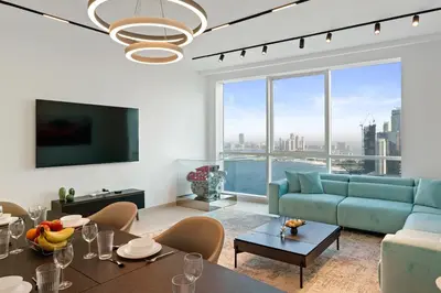 a living room with a blue couch and a large window at Ferrari Inspired Modern 3BHK with maids room and Full Sea View in Dubai