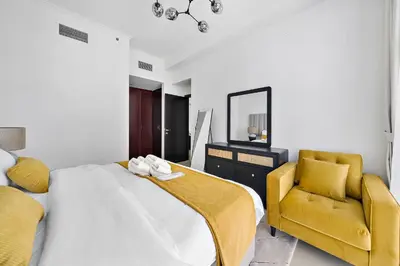 a bedroom with a bed and a mirror and a chair at Newly-furnished 1BR at DEC Tower 2 in Dubai