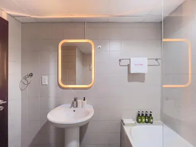 a bathroom with a sink and a mirror and a tub at Lovely Studio at The Arch Tower JLT in Dubai