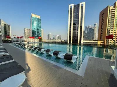 a pool with lounge chairs and a city skyline at Wohnung im Stadtzentrum von Dubai in Dubai