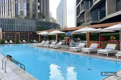 a large swimming pool with chairs and umbrellas at 3 BHK Luxury Living at The Address Opera in Dubai