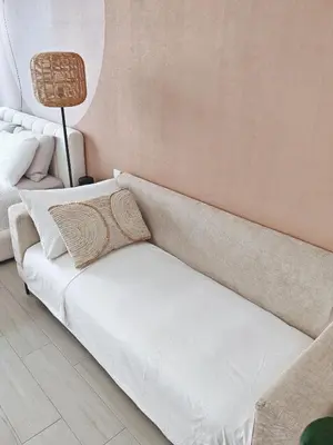 a white couch in a room with a lamp at Chic Modern Studio in Luma21, Best Pool & Gym in JVC Dubai in Dubai