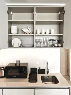a kitchen counter with a sink and a microwave at Chic Modern Studio in Luma21, Best Pool & Gym in JVC Dubai in Dubai