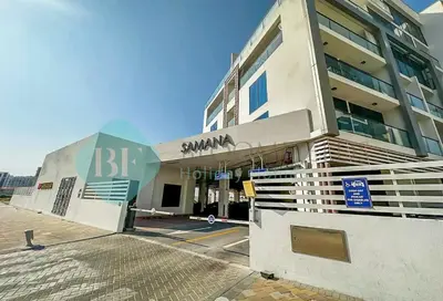 a building with a sign on the side of it at Bloomfields Luxury Escape Studio In Samana Golf in Dubai