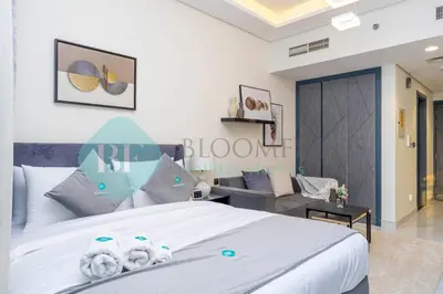 a bedroom with a large white bed and a couch at Bloomfields Luxury Escape Studio In Samana Golf in Dubai