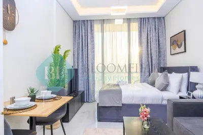a bedroom with a bed and a dining room at Bloomfields Luxury Escape Studio In Samana Golf in Dubai