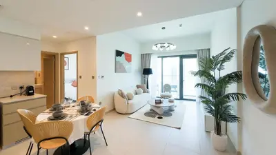 a kitchen and living room with a table and chairs at Cozy 1-BR in the heart of Dubai with skyline views in Dubai