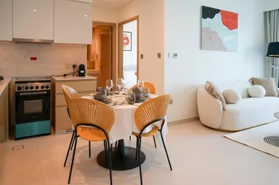 a kitchen and living room with a table and chairs at Cozy 1-BR in the heart of Dubai with skyline views in Dubai